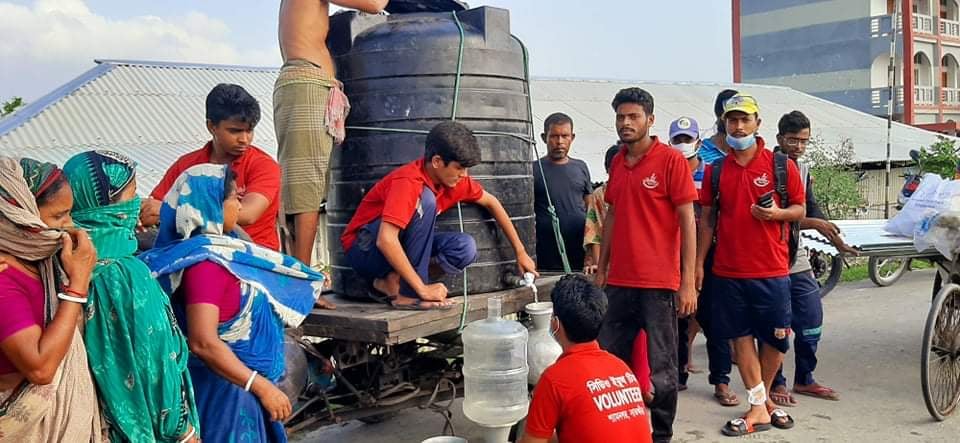 Bangladeshis organize water distribution after a cyclone.